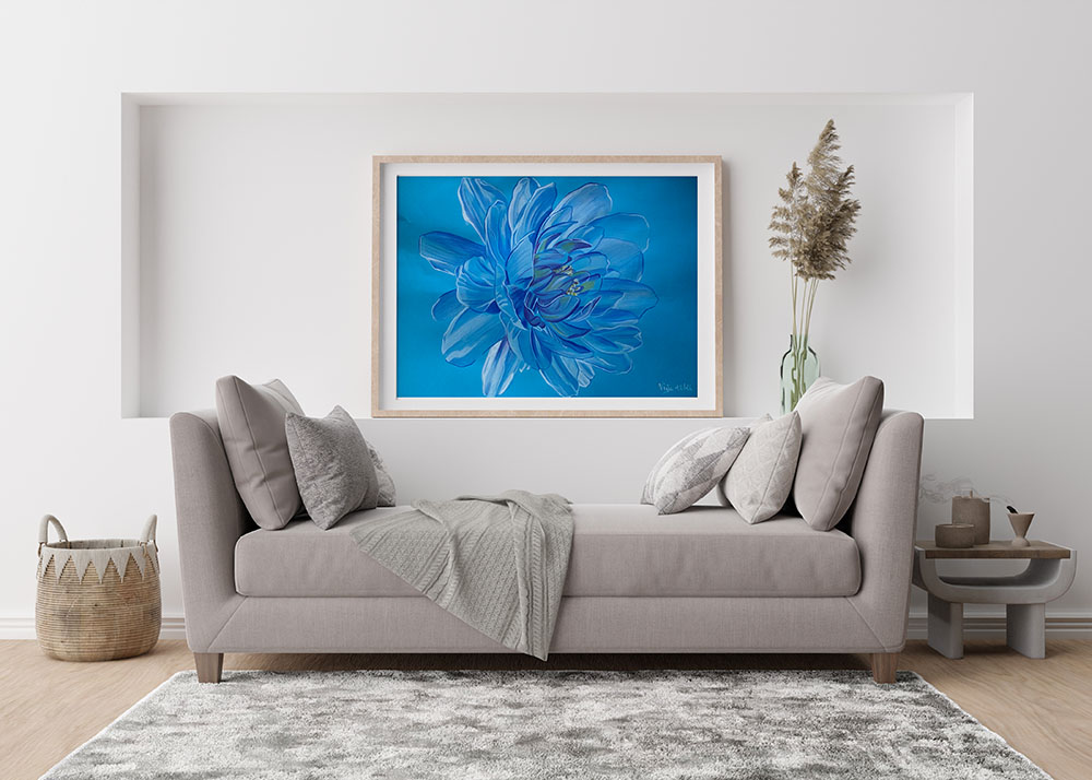 Dessin d'une fleur de nénuphar, dans un camaïeu de bleus, encadré et accroché au mur au dessus d'un canapé.