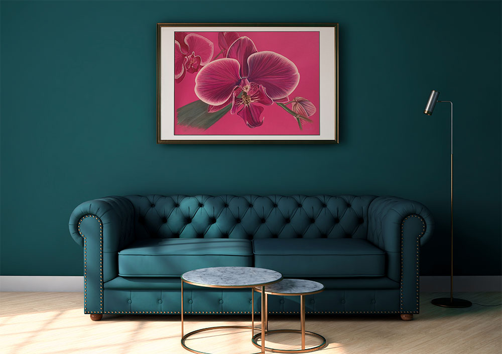 Dessin d'une orchidée rose sur un mur vert au dessus d'un canapé vert